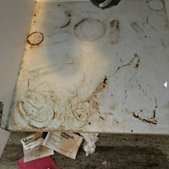 Under-sink cabinet before deep cleaning in Abbotsford. Rust stains and debris